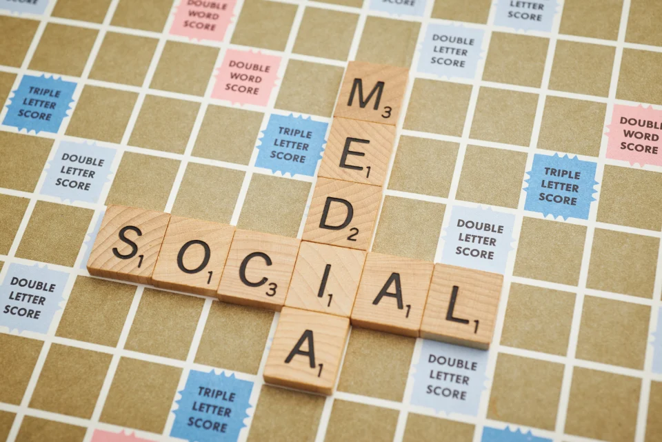 Letter tiles spelling social media on a wooden table