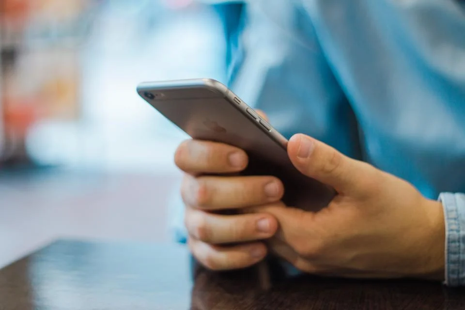 Hand holding a smartphone to check social media profiles